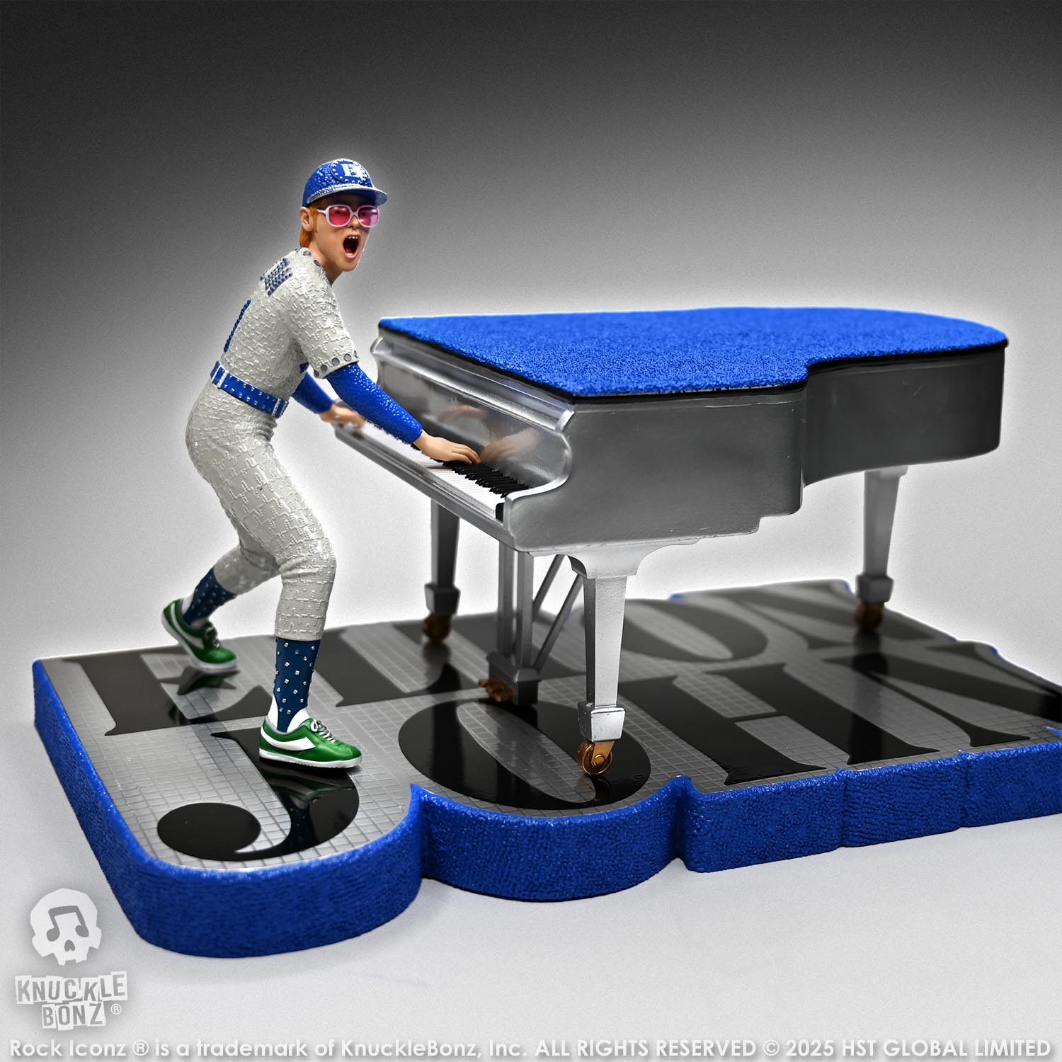 Statue of Elton John with a grand piano in a baseball uniform with a white background