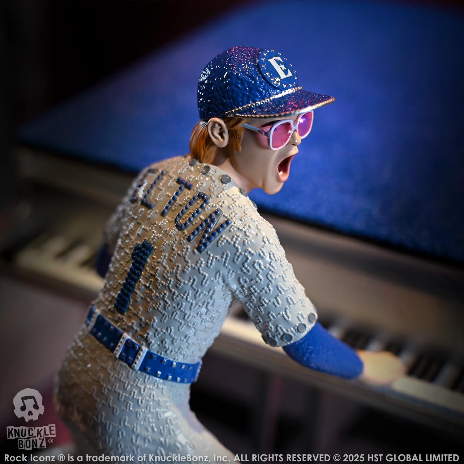 Statue of Elton John with a grand piano in a baseball uniform with a dark background