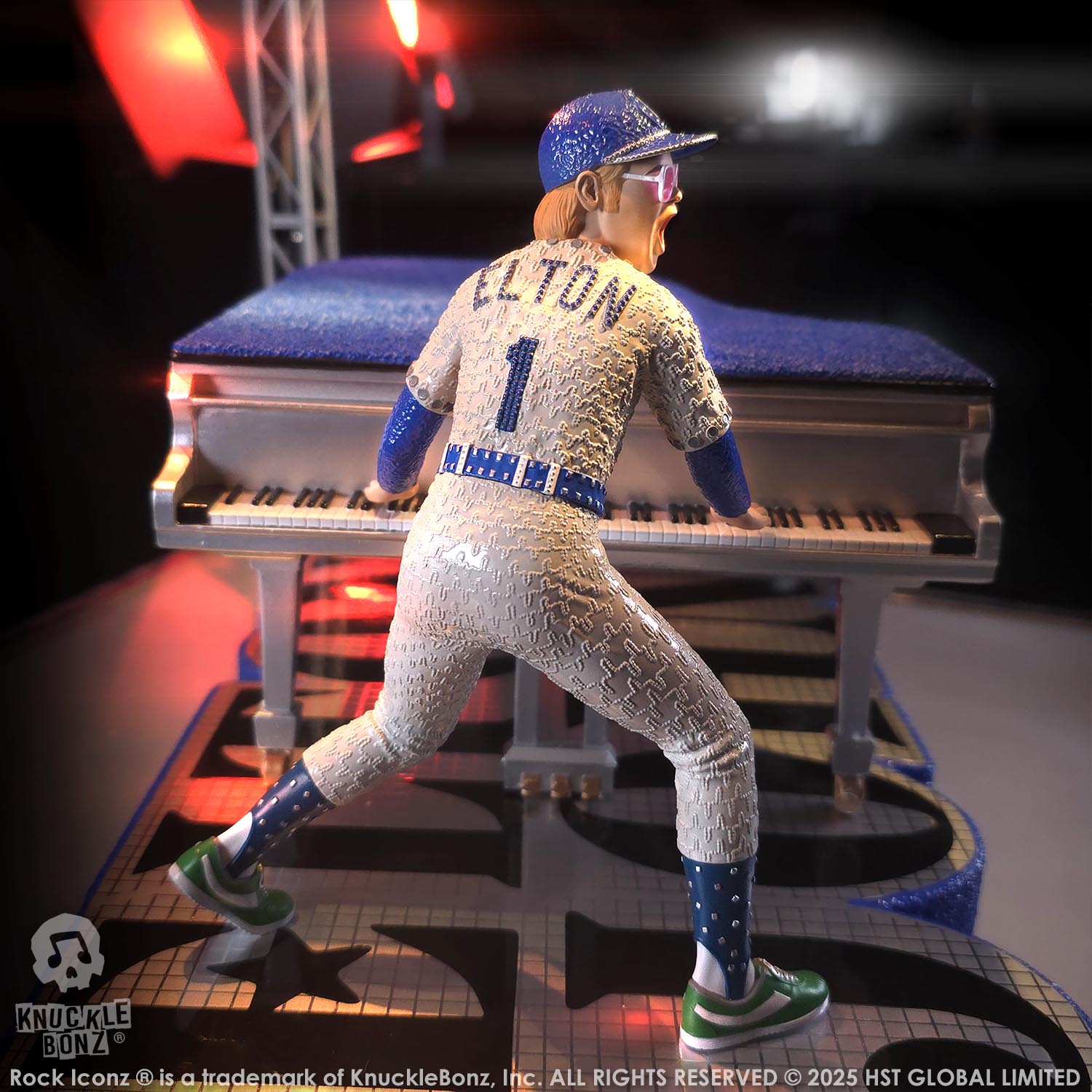 Statue of Elton John with a grand piano in a baseball uniform with a dark background