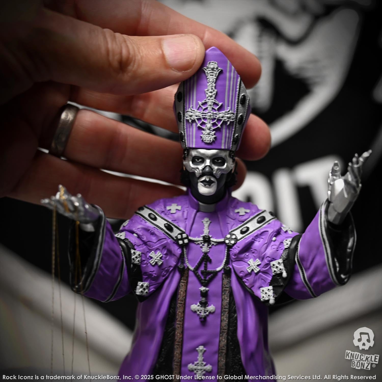 Purple and black Statue of Papa V Perpetua from Ghost held by a hand.