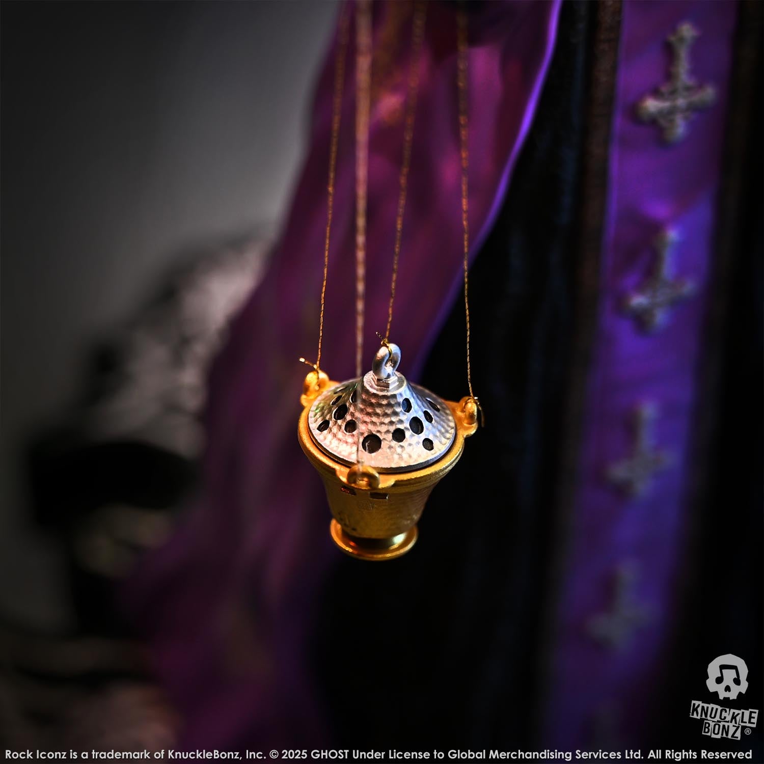 Statue of Papa V Perpetua from Ghost with a decorative hanging incense burner with a purple fabric background