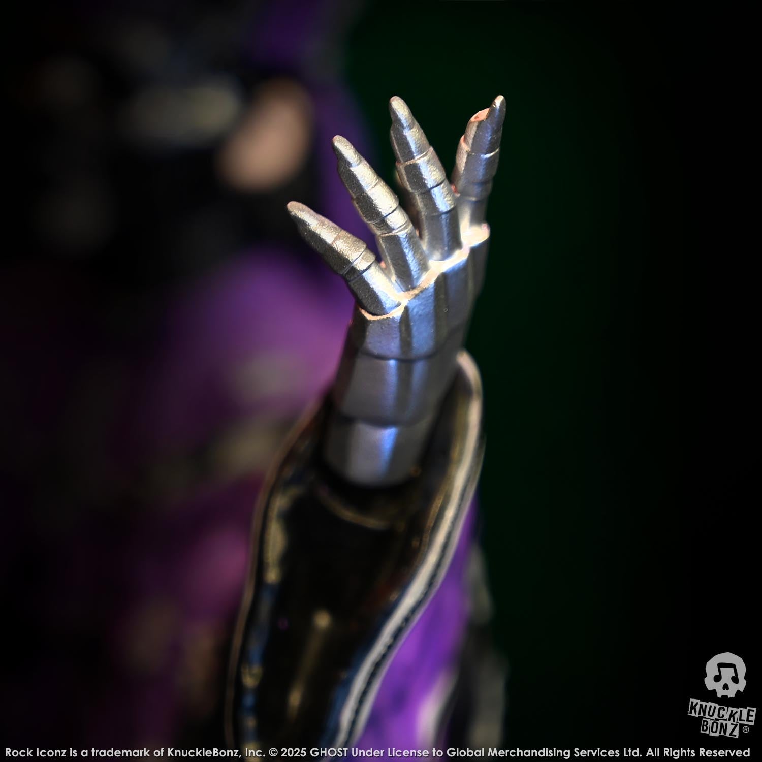 Metallic clawed hand on a dark background with 'Knucklebonz' branding.