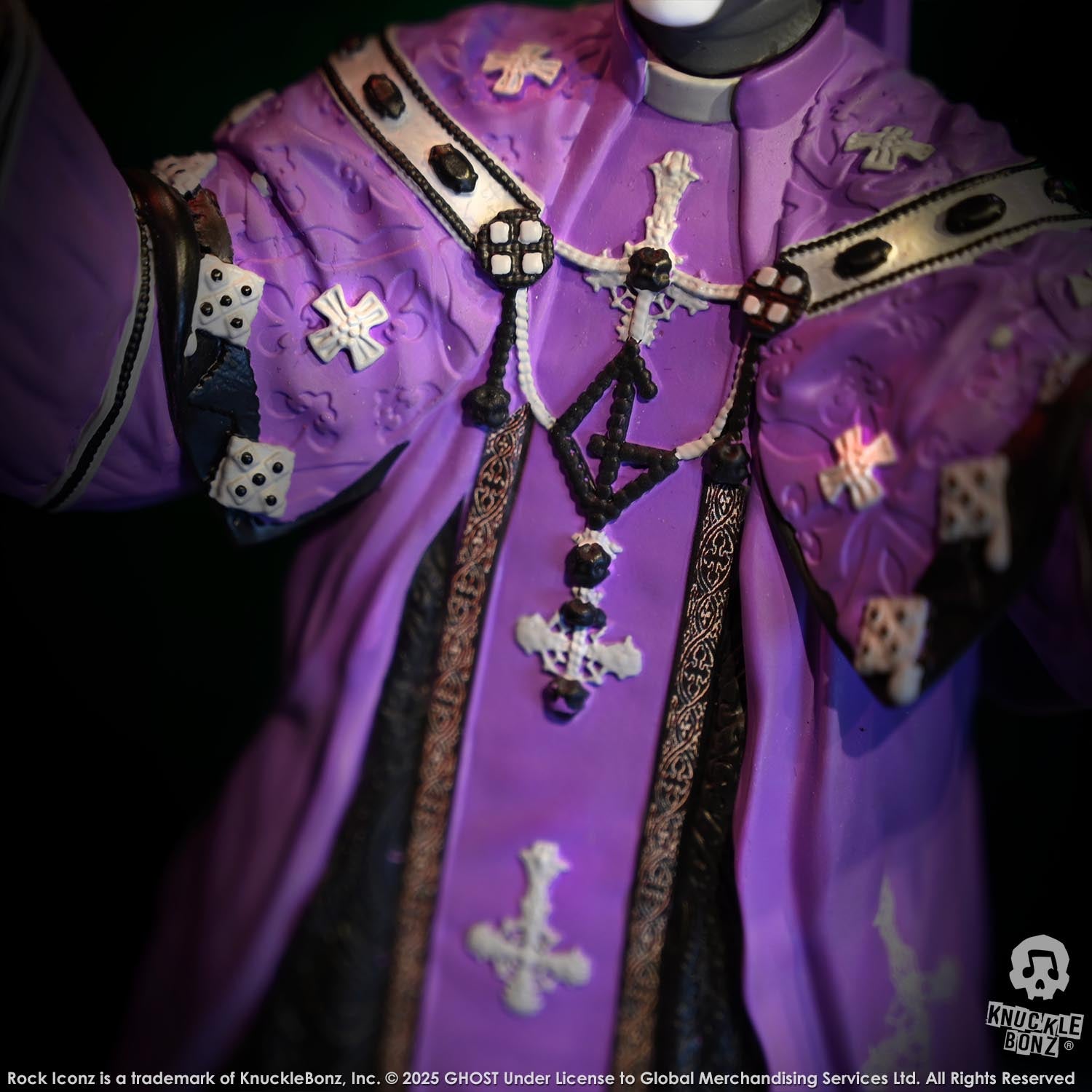 Close-up of the statue with a purple robe with decorative elements on a black background