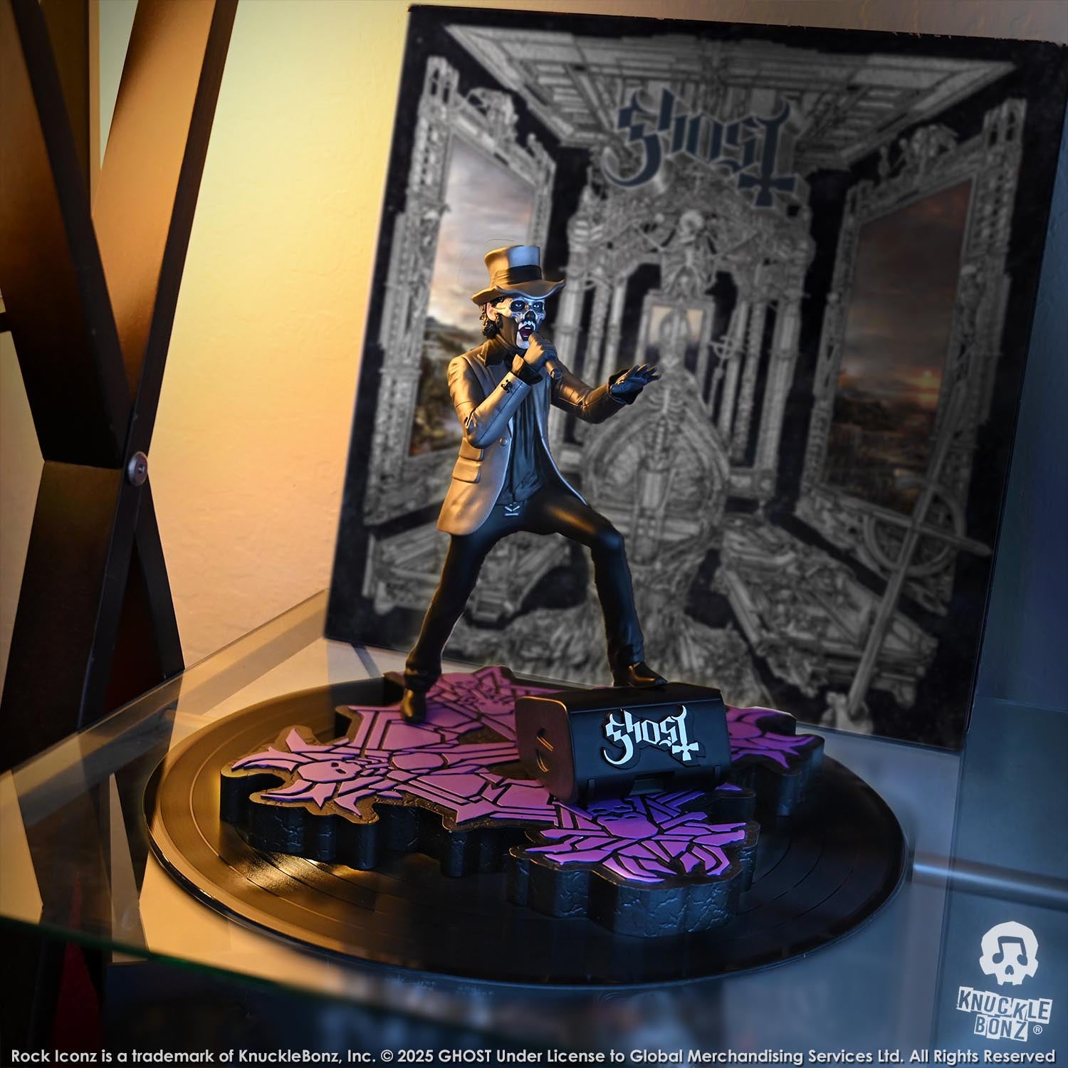 Statue of Papa V Perpetua from Ghost in a silver suit coat and top hat with a Ghost album in the background